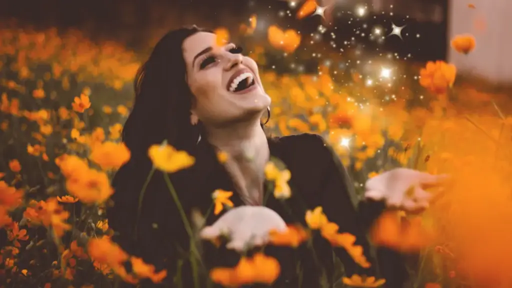 Frau lacht im Blumenfeld – Befreiung und Selbstliebe nach emotionaler Abhängigkeit